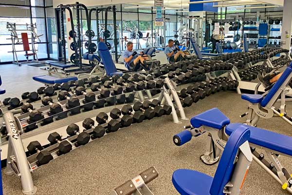 dumbbell rack with strength equipment and man working out